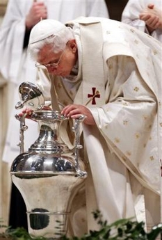 Paus Benedictus XVI tijdens de viering van de Chrismamis terwijl hij blaast over een anaphor met de chrisma-olie.